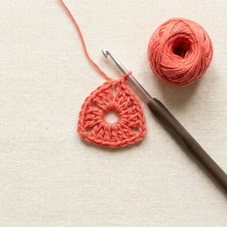 Round 1 center ring with three double crochet groups for a triangle motif