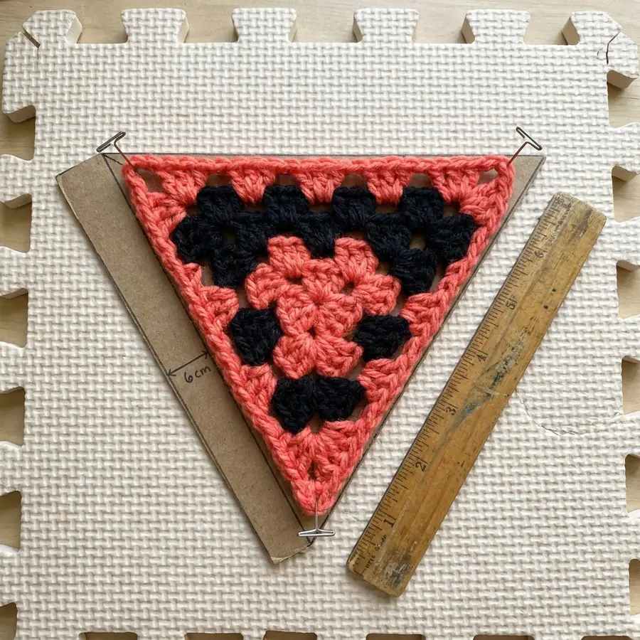 Completed coral triangle motif with an even black single crochet border