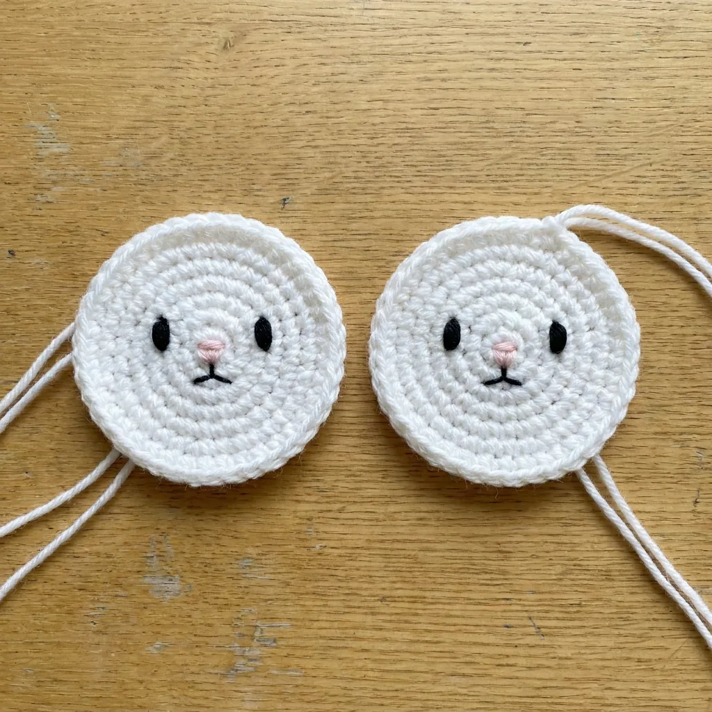 Two embroidered crochet bunny face circles