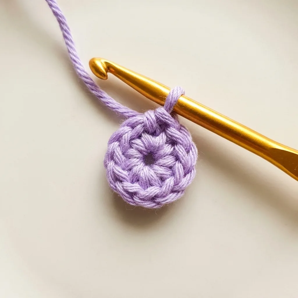 Small lavender crochet center being closed with one slip stitch