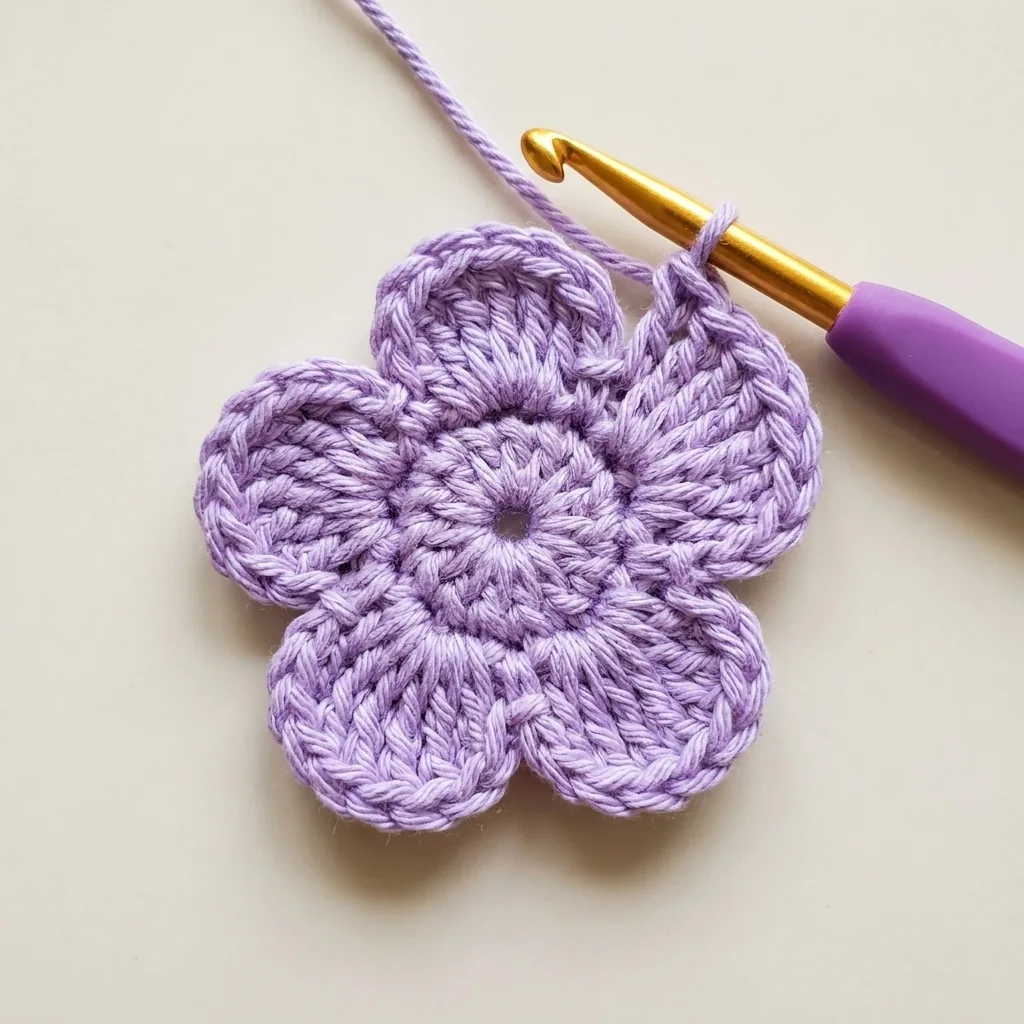 First round forming five lavender crochet petals around the center