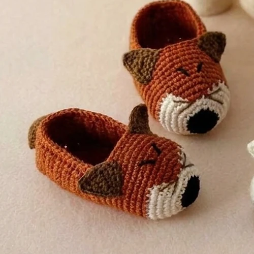Rust fox crochet baby booties with triangular brown ears and cream toe details
