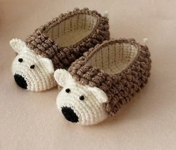 Taupe hedgehog crochet baby booties with cream faces and looped surface texture