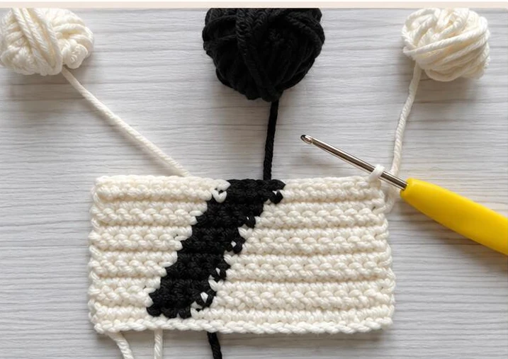 Ten-row practice swatch attached to three cream and black bobbins
