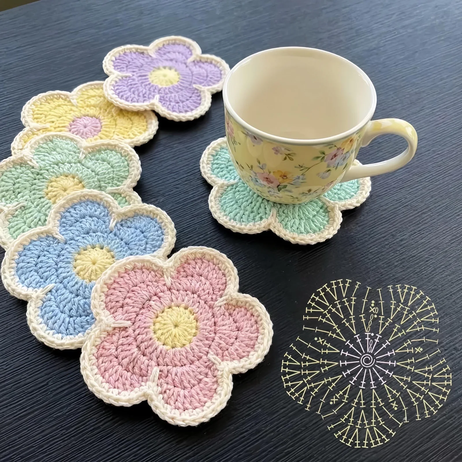 Pastel crochet flower coasters arranged around a floral teacup