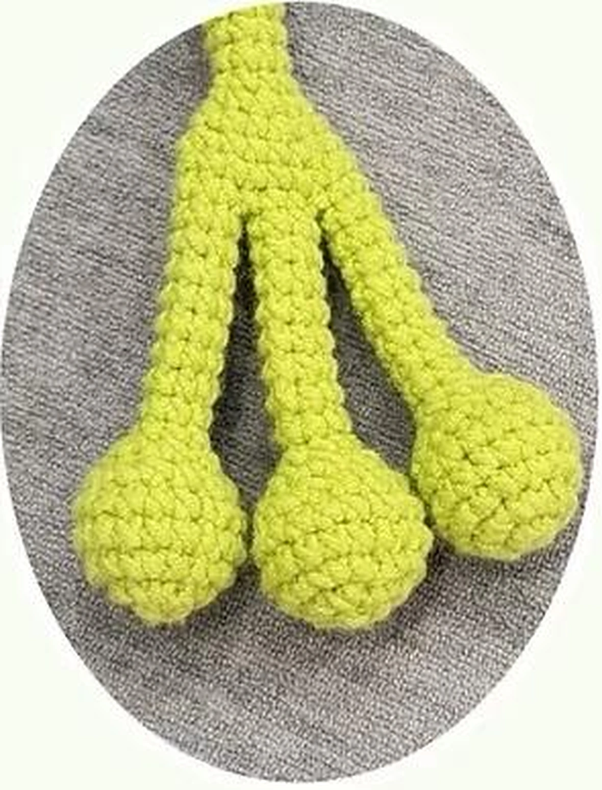 Three rounded green crochet toes joined into a slender frog leg