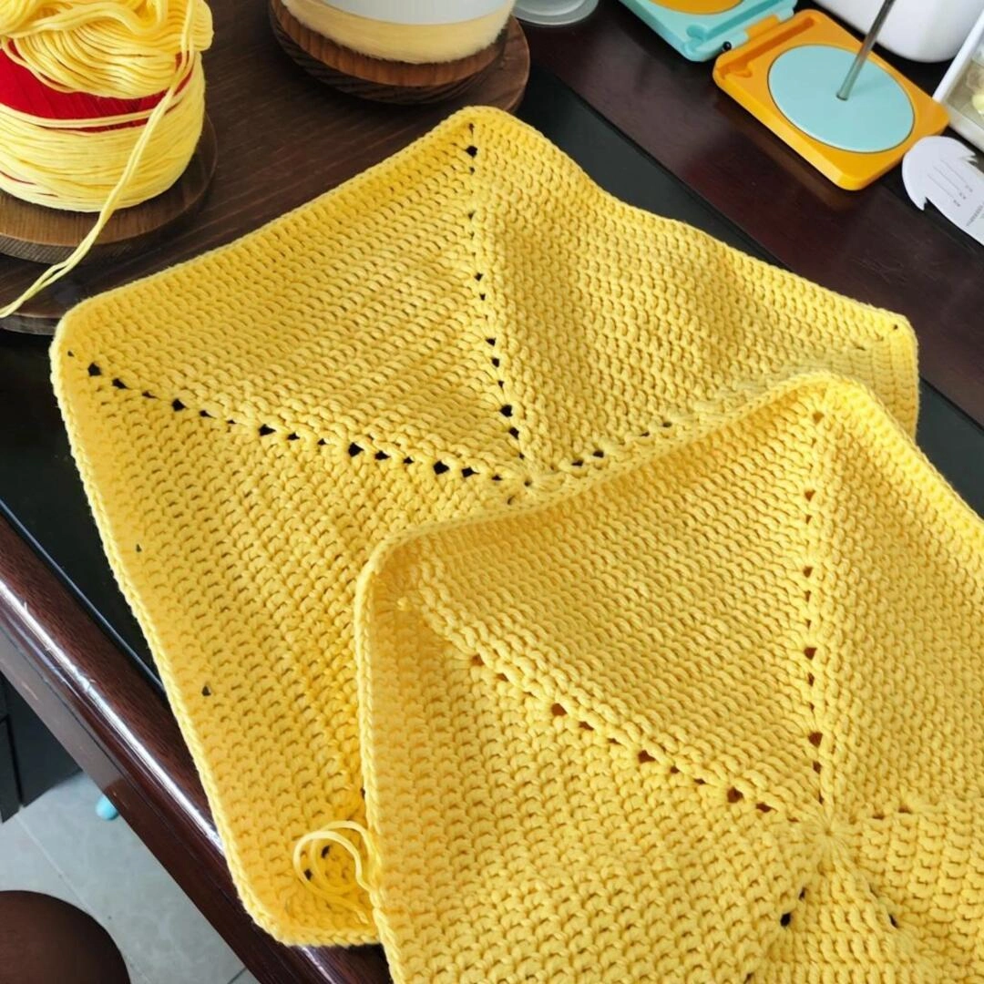 Two complete yellow crochet star panels before joining