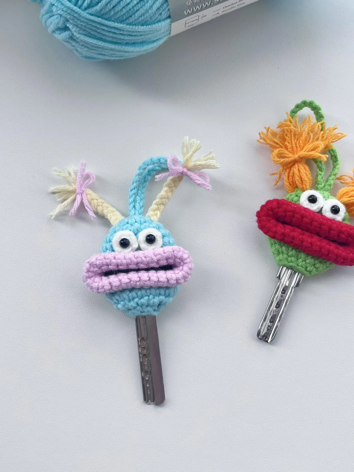 Turquoise crochet monster key cover with lilac lips and cream braided pigtails