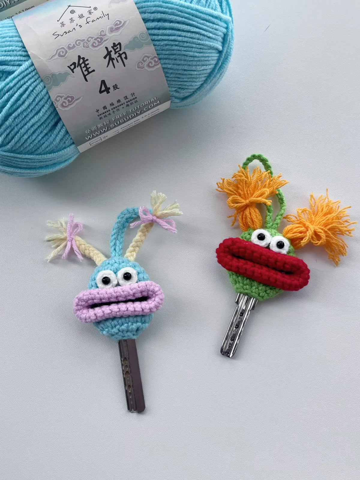 Crochet monster key cover pair in turquoise and green with colorful lips and braided yarn hair