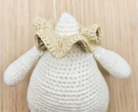 Place the joined ruffled collar around the neck before adding the head.