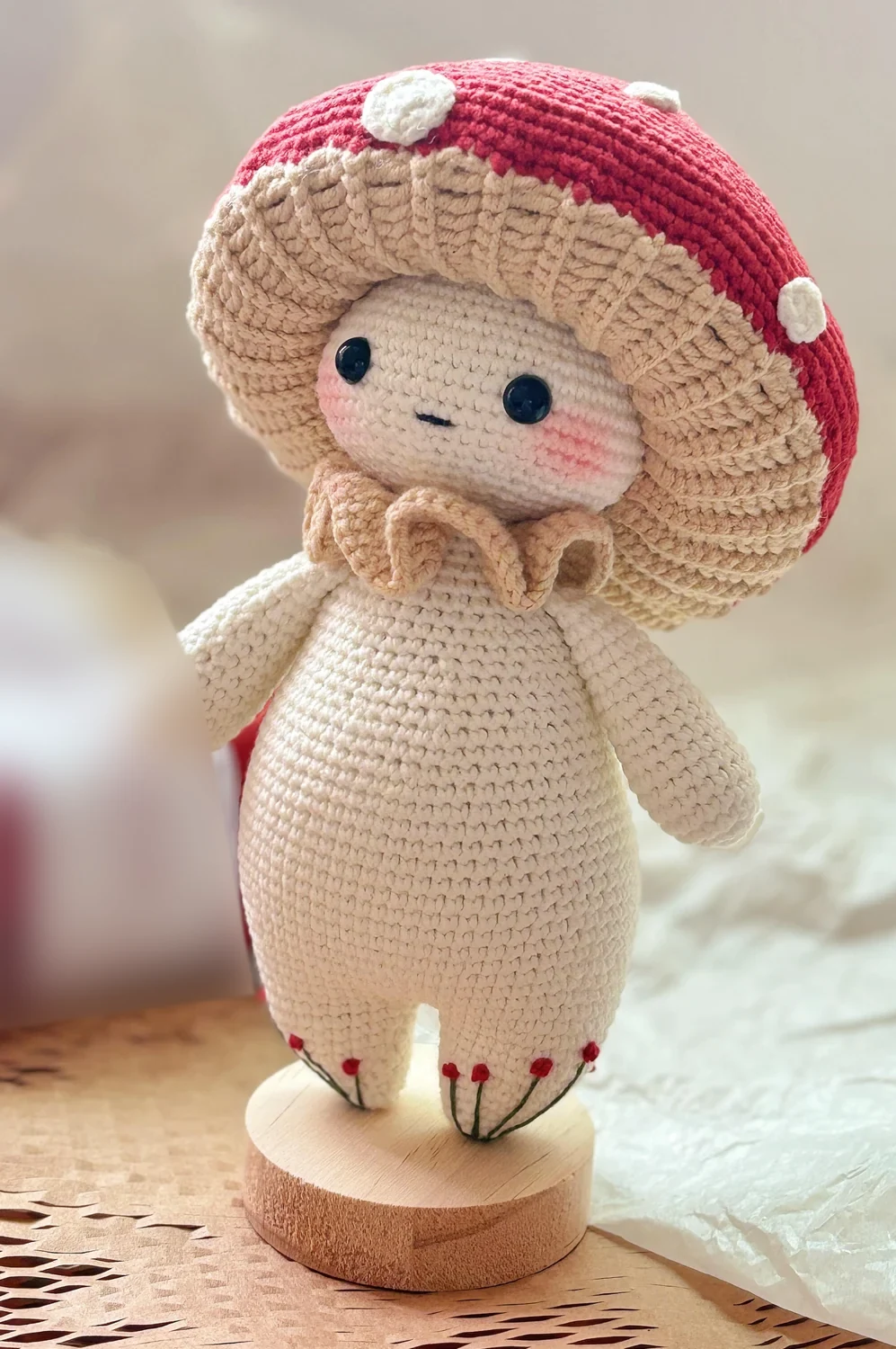 Cream crochet forest sprite with red spotted mushroom cap and ruffled collar