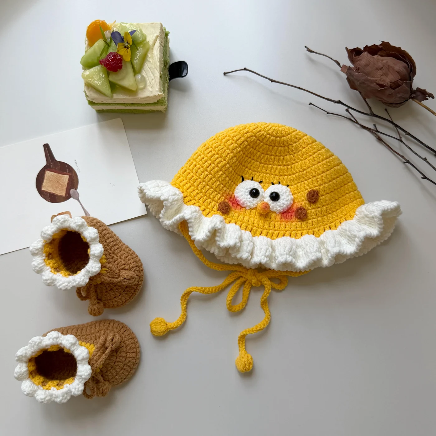 Yellow crochet ruffle hat reference with white wavy brim and brown face spots