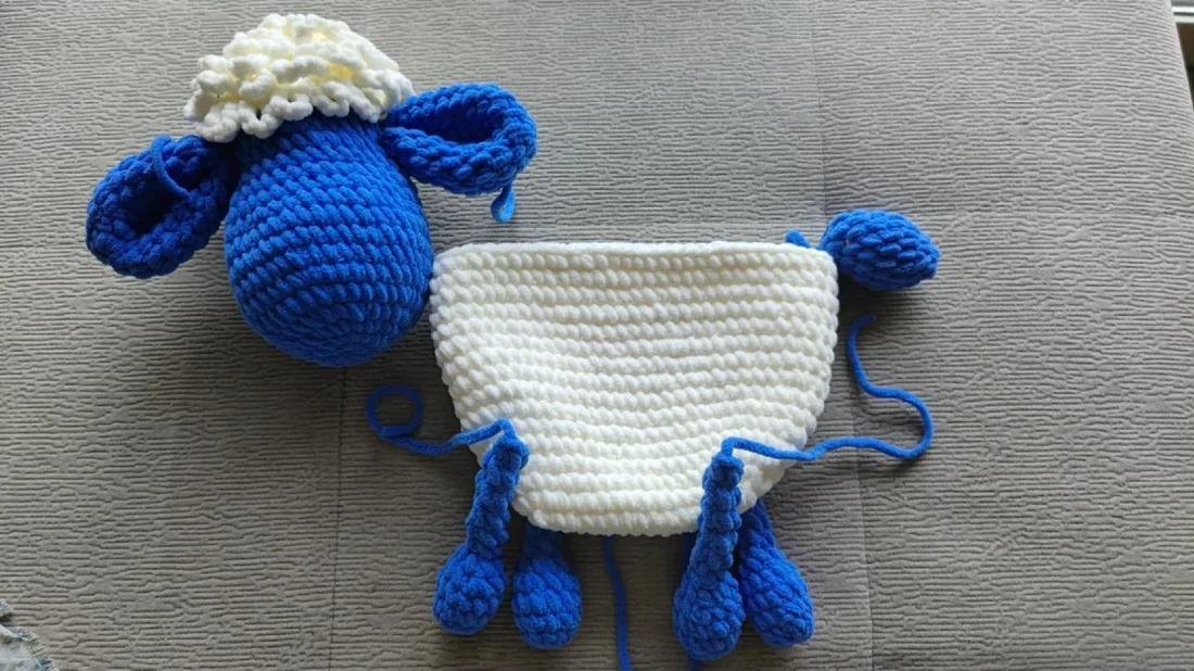 Crocheted sheep head and white bag body arranged before assembly