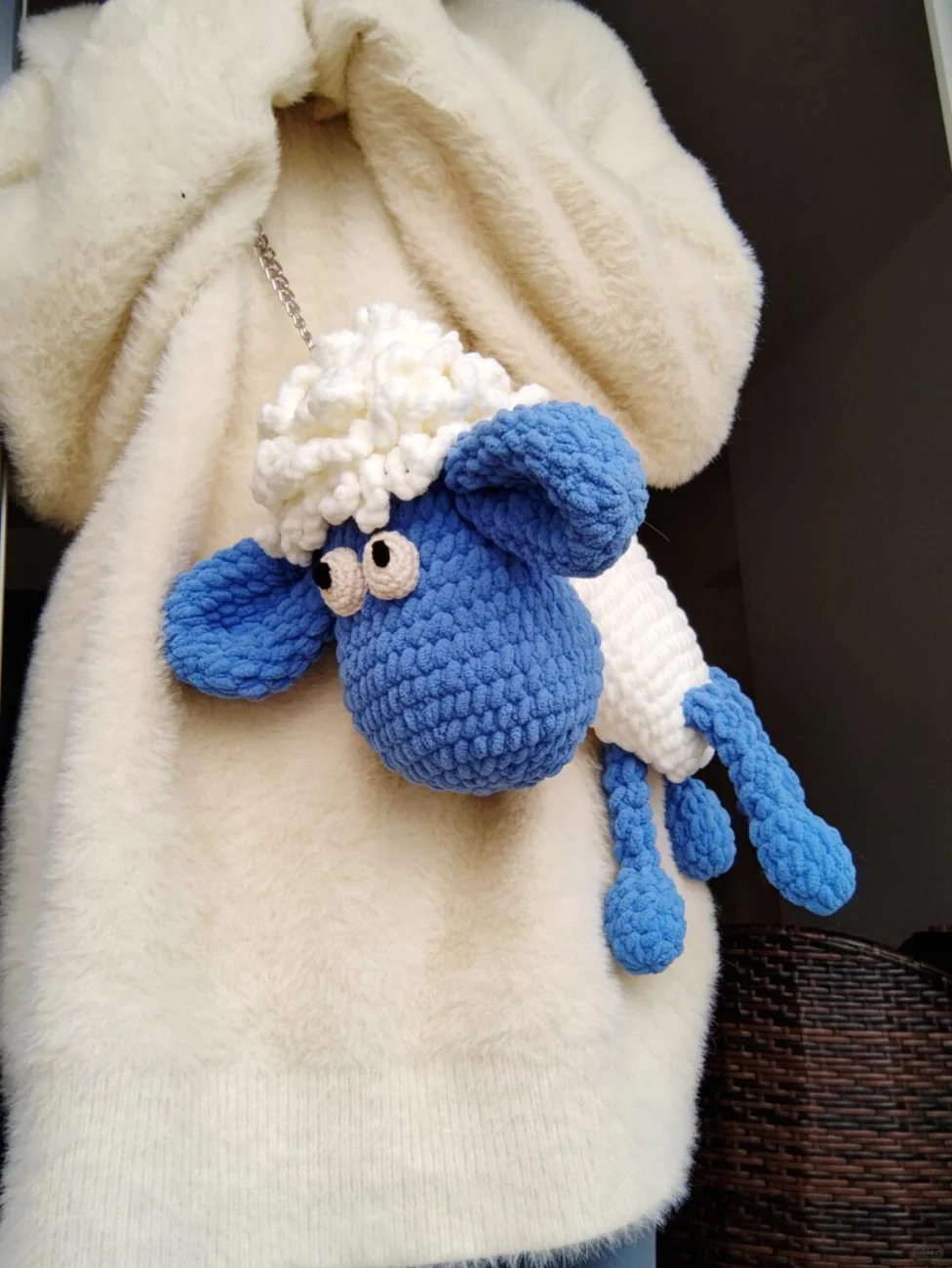 Sheep bag crochet pattern in blue and white, worn with a cream coat