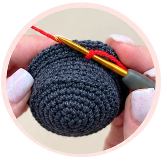 Attaching red yarn to the free hat loops