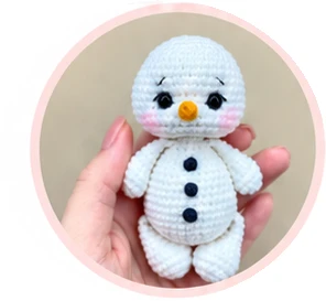 Assembled snowman with three dark crochet buttons before dressing