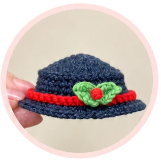 Snowman hat with red band and green leaves with a red berry