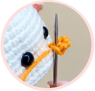 Attaching the orange carrot nose, photograph 1