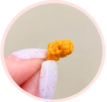 Small orange crochet carrot nose before sewing