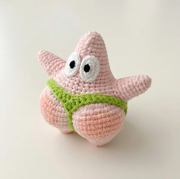 AI finished crochet starfish charm concept with pink body and green garment