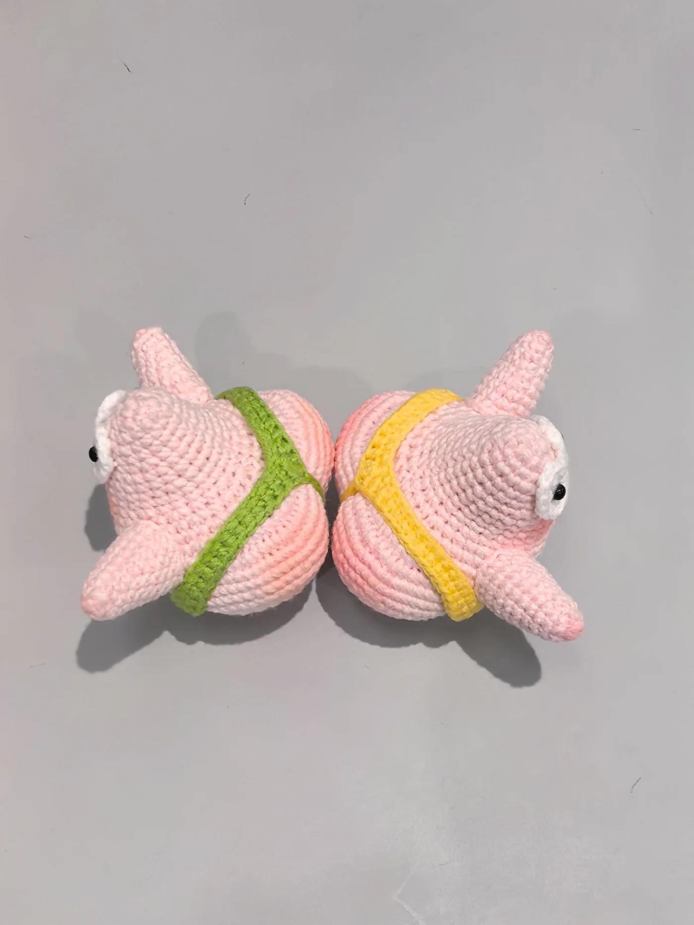 Crochet starfish charm pair in pink with green and yellow waistbands